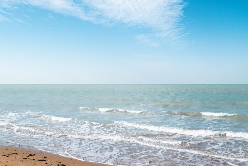 a sandy beach with waves coming in to shore