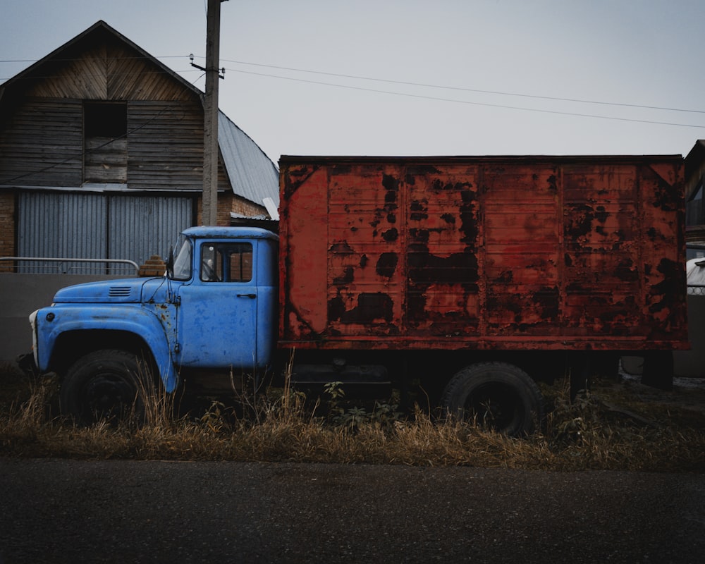 a blue and red truck parked in front of a building