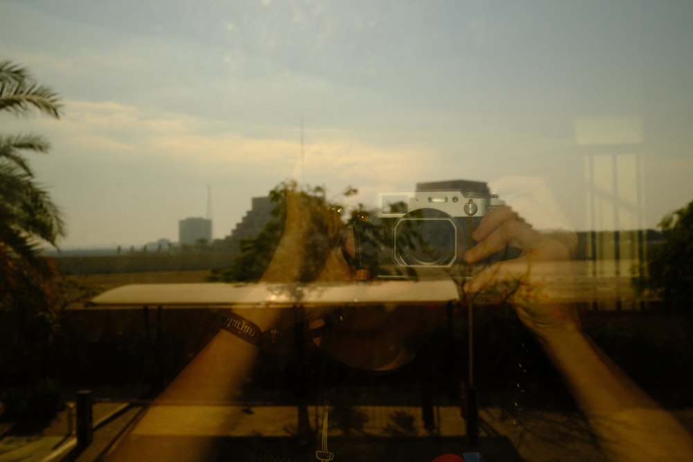 Una persona tomando una foto a través de una ventana