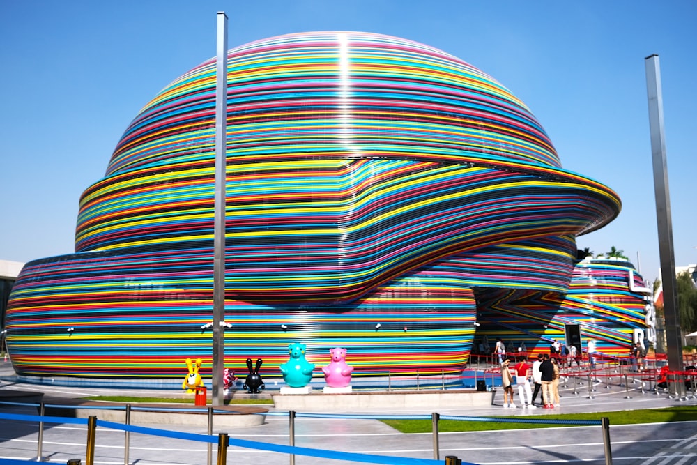 a colorful building with people walking around it