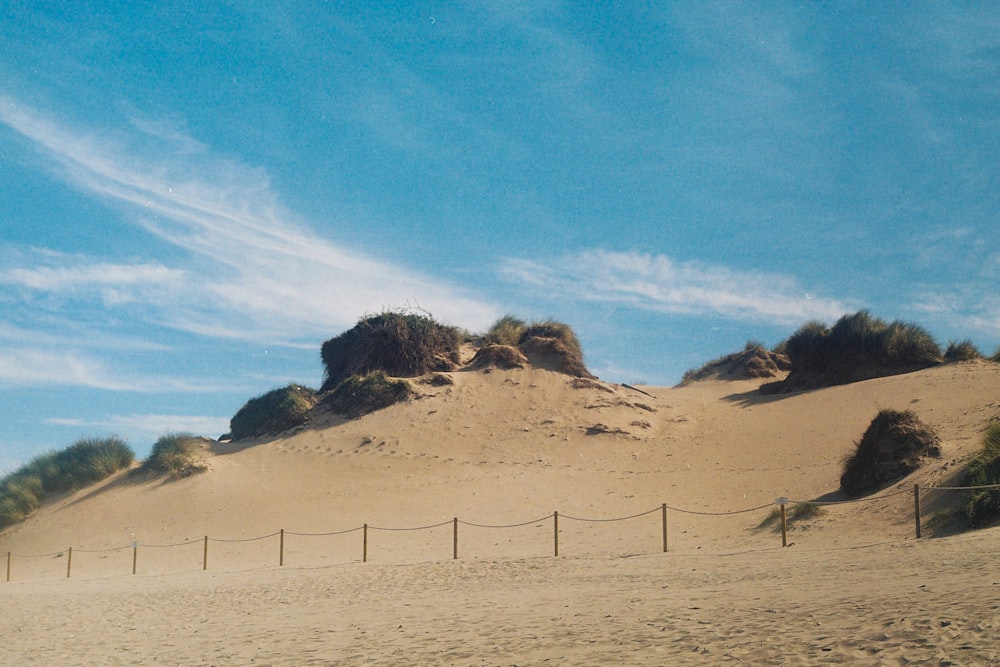 a beach with a fence and sand dunes
