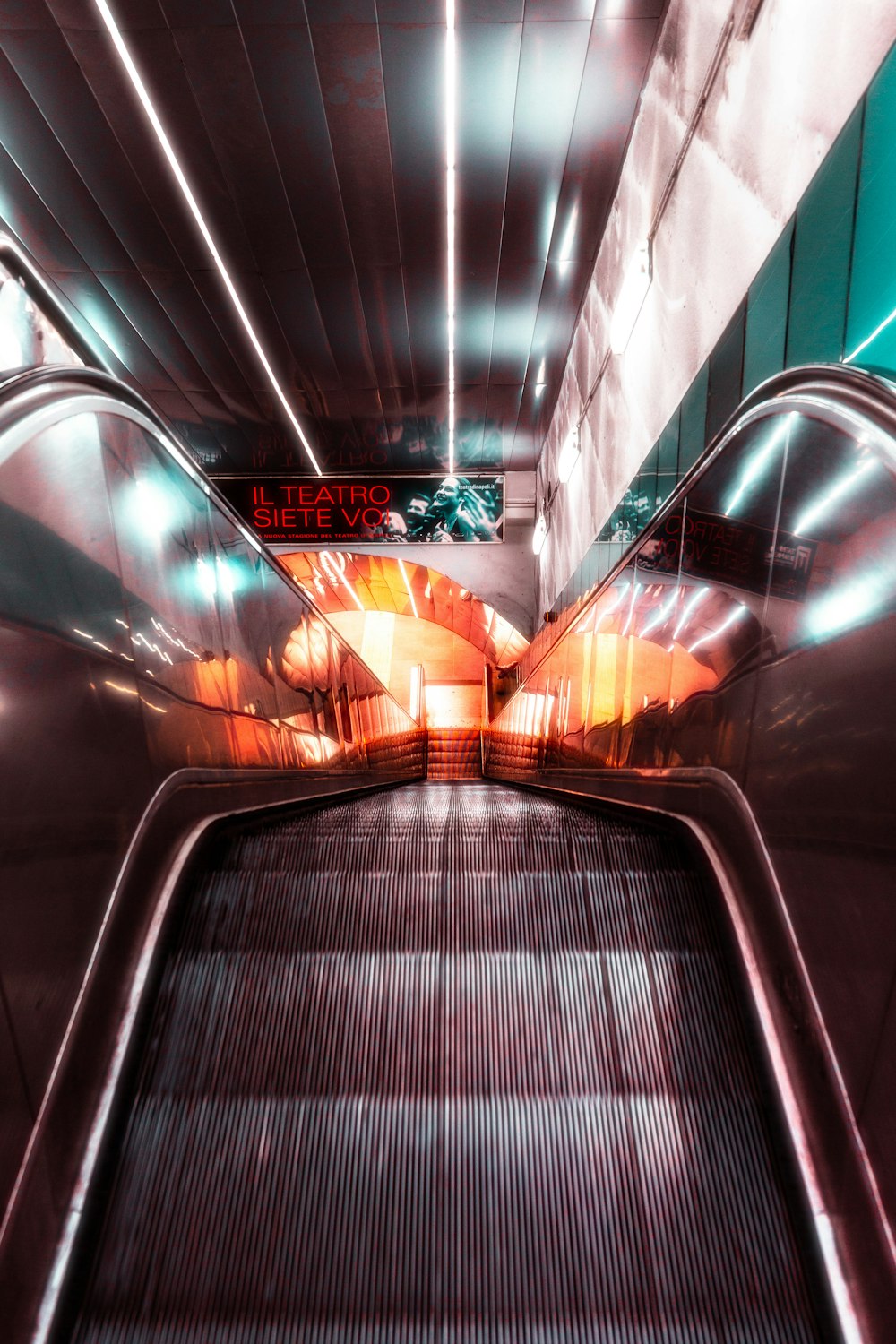 an escalator in a subway station with a sign on it