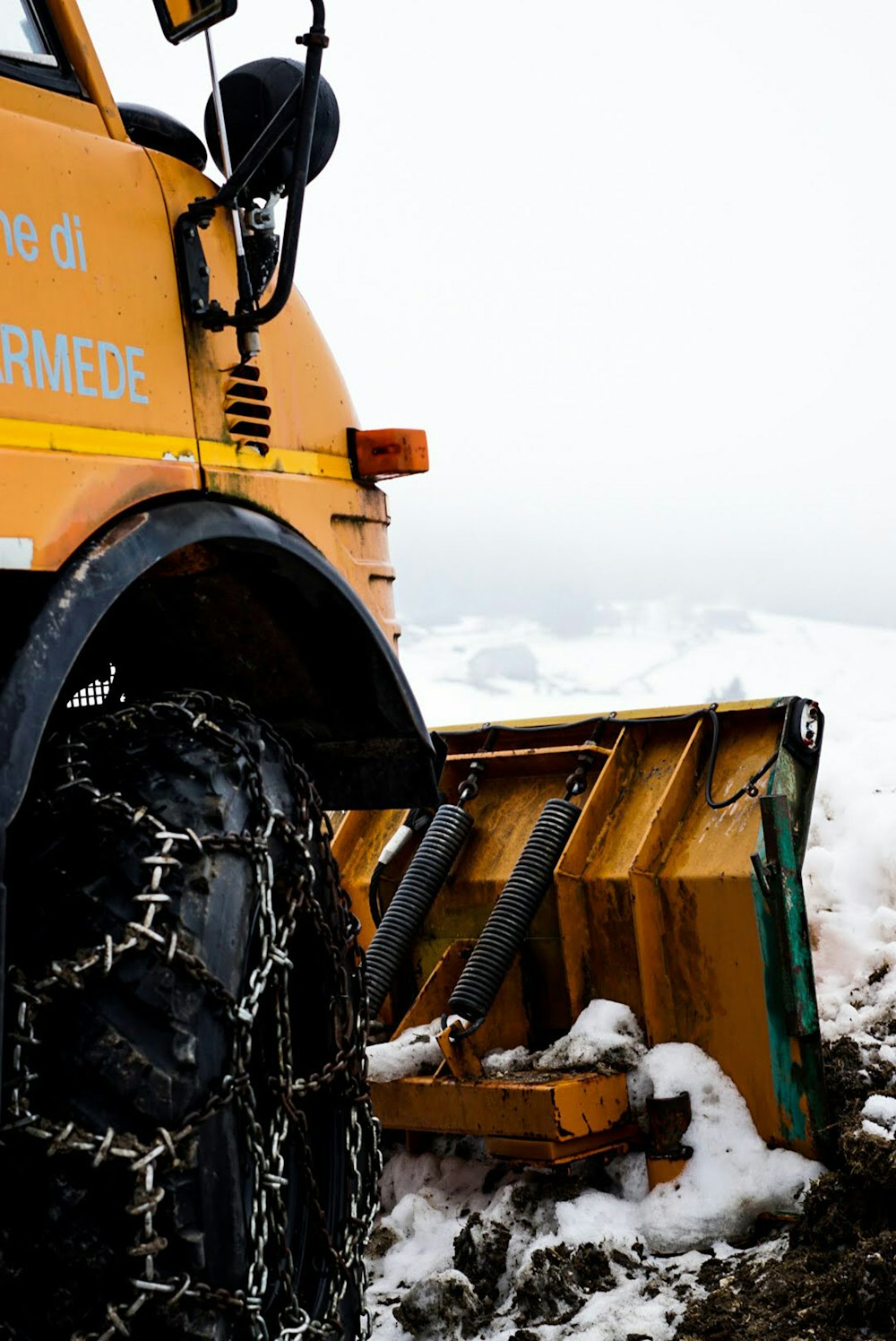 a yellow dump truck parked on top of snow covered ground