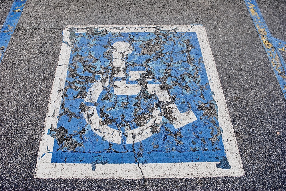 a blue and white sign on the side of a road