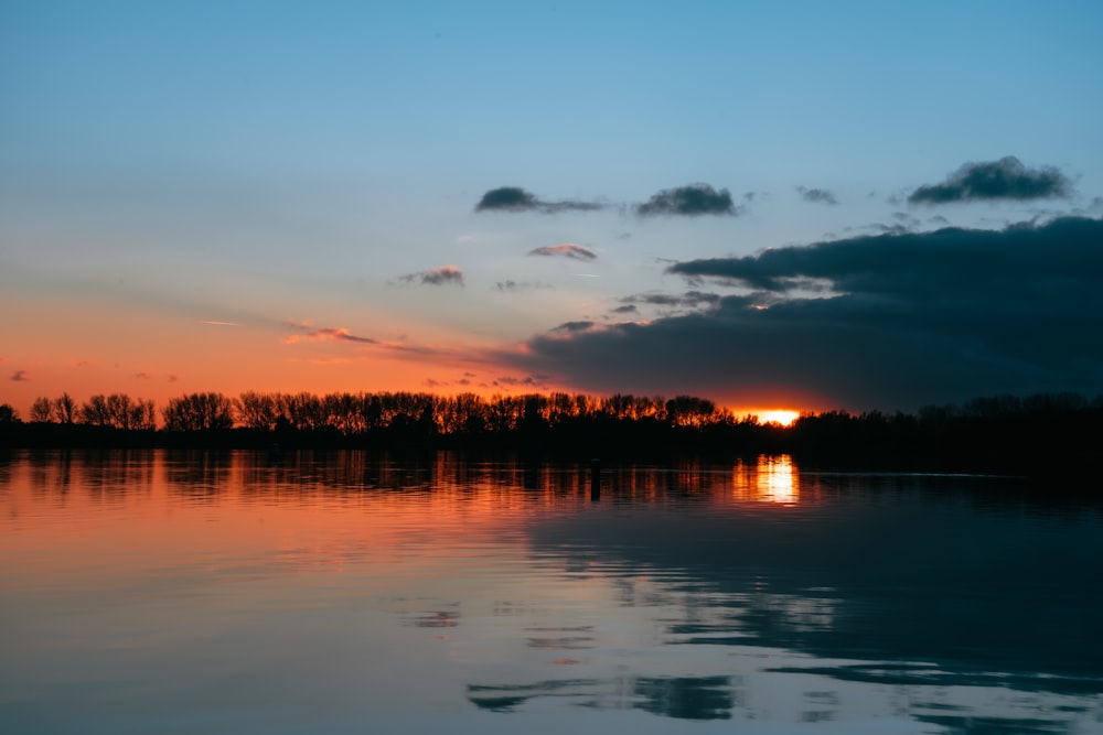 the sun is setting over a body of water