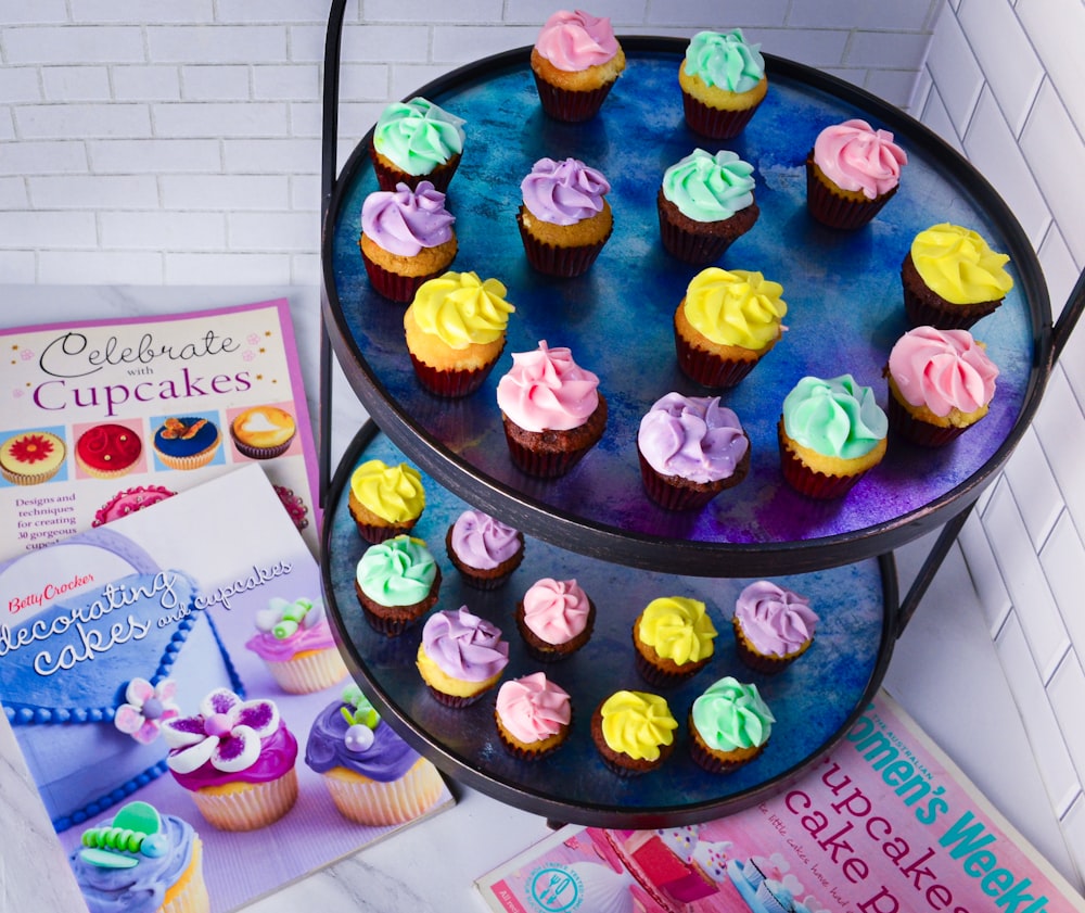 a three tiered cake stand with cupcakes on it