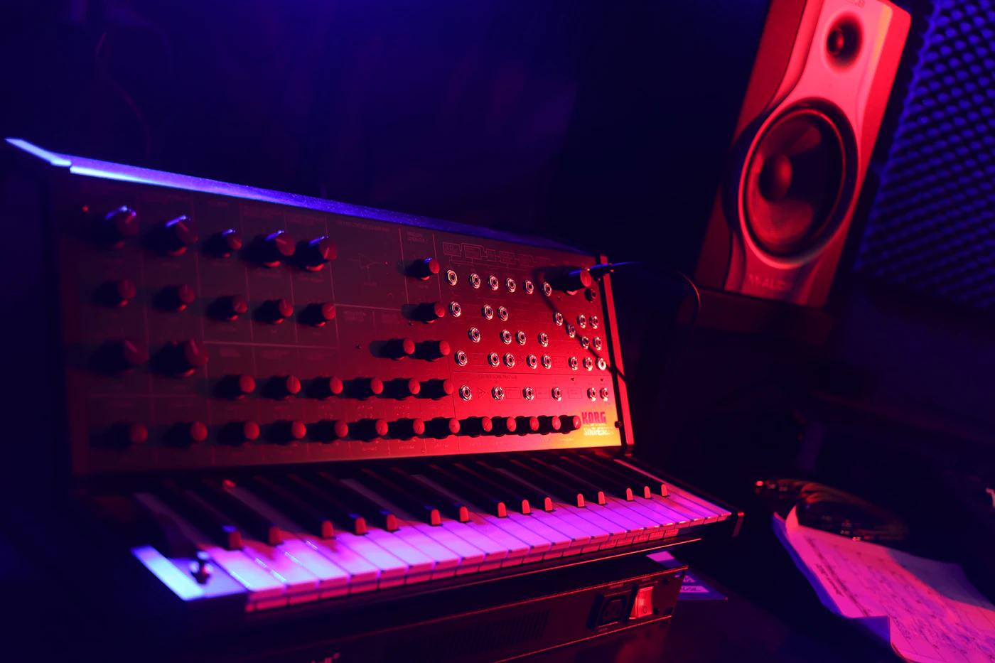 A keyboard and a speaker in a dark room