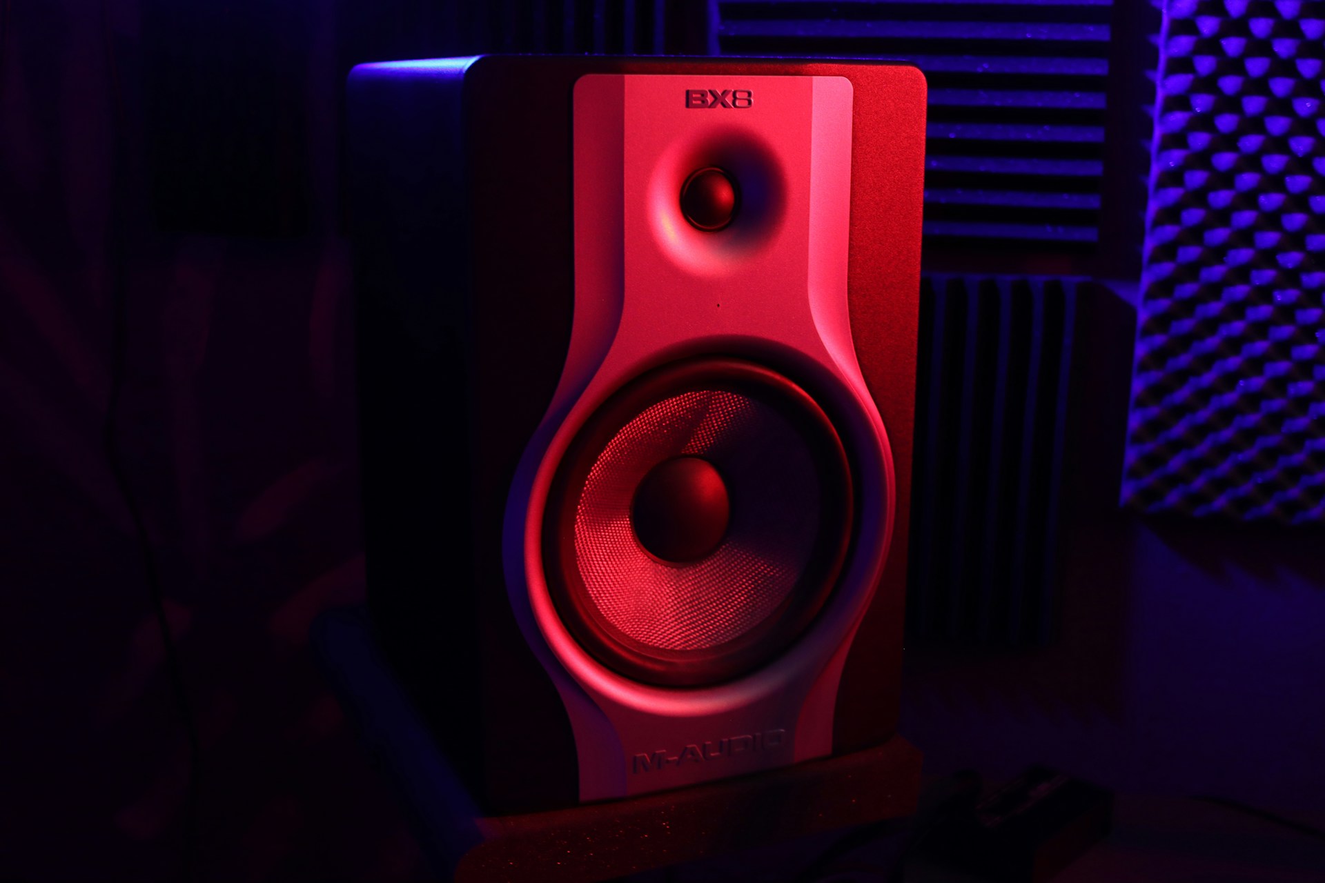 a red and black speaker sitting on top of a desk