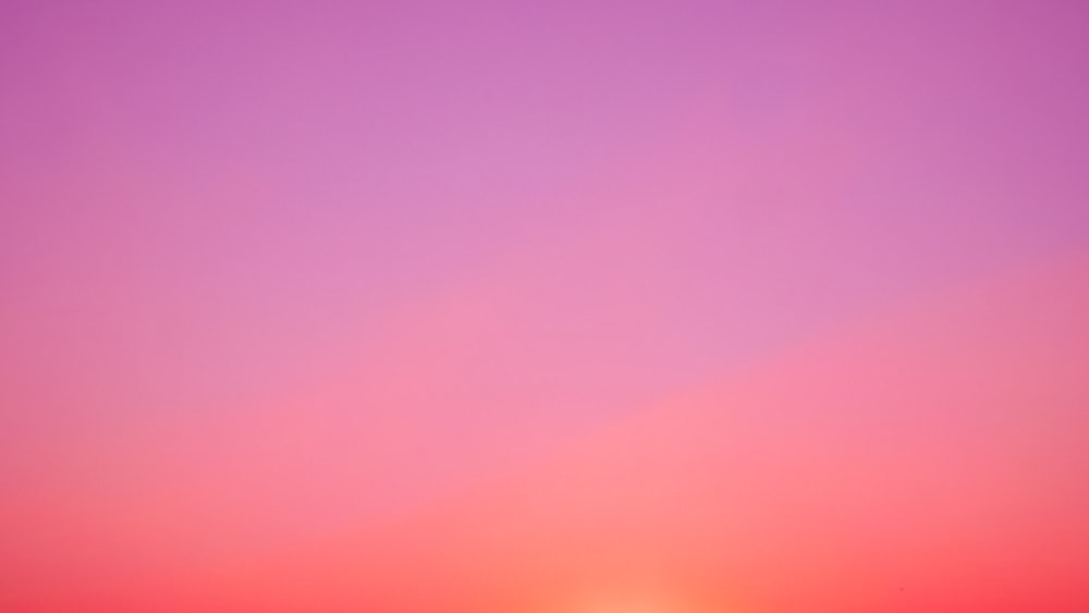 the sun is setting over the horizon of a beach