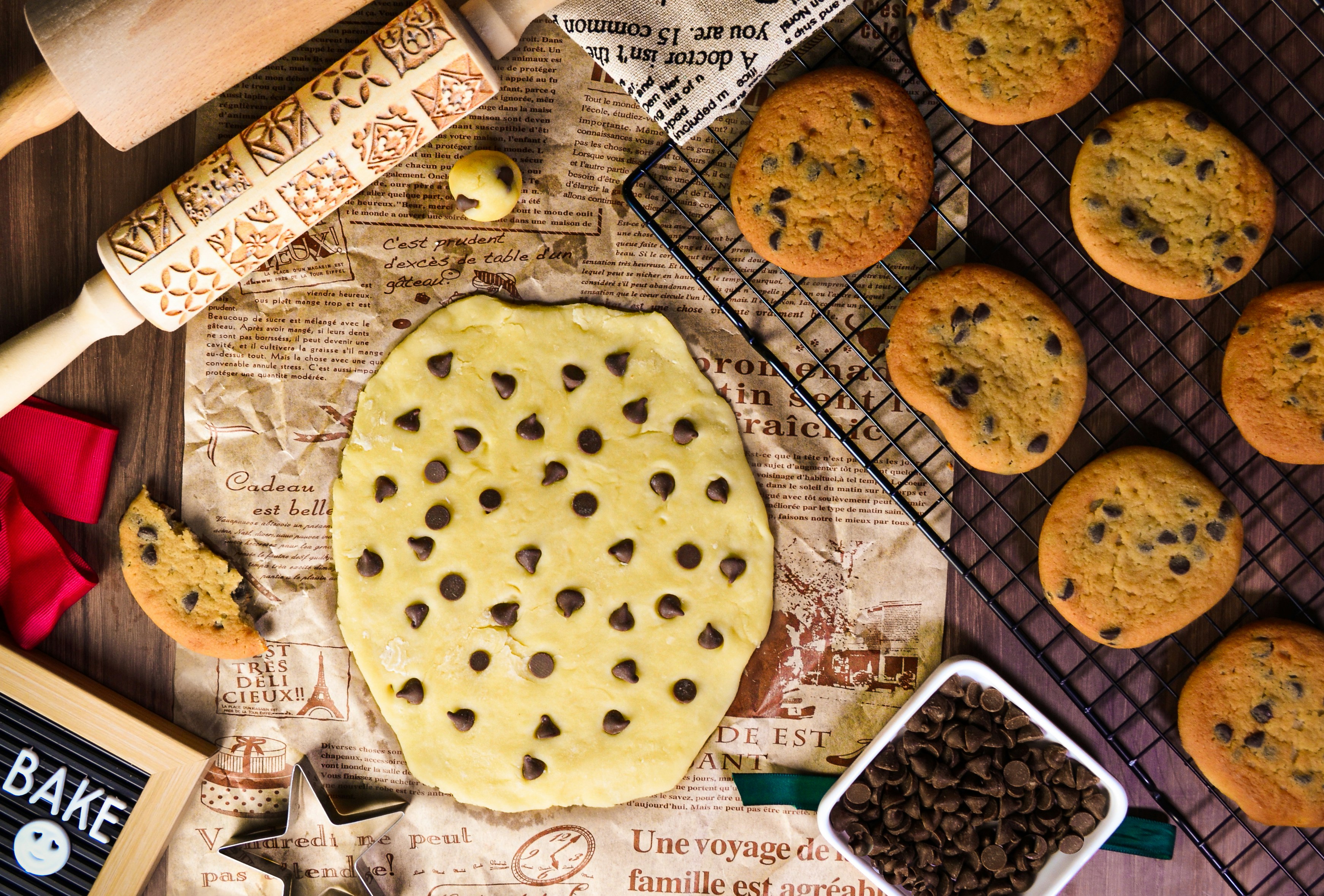 un biscotto con gocce di cioccolato in cima a un tavolo accanto agli utensili da forno