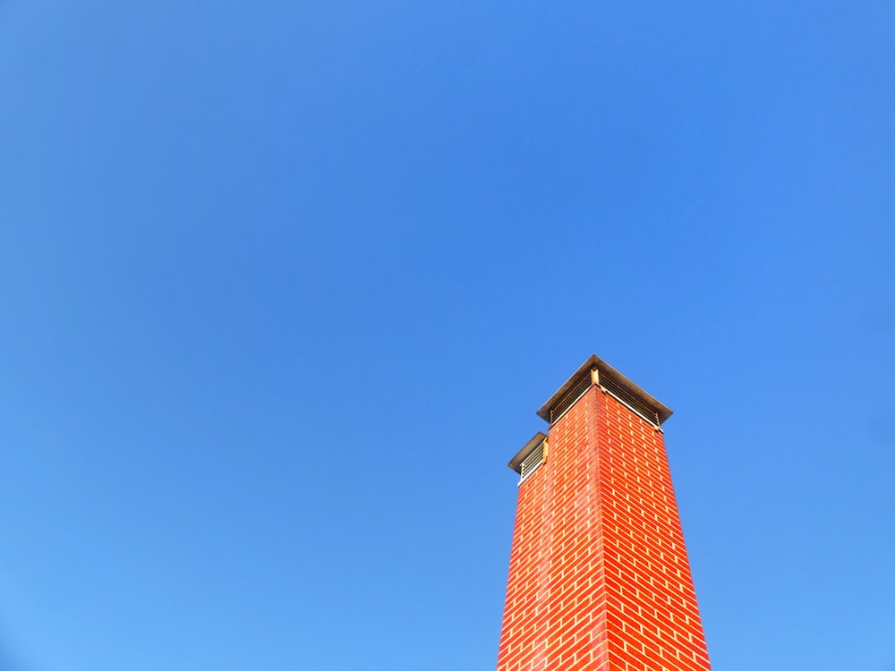 a very tall red building with a clock on it's side