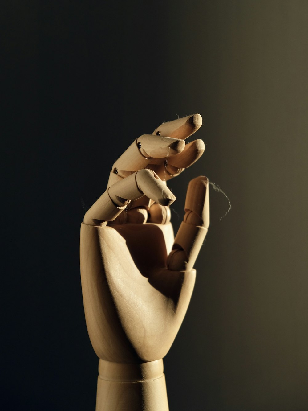 a wooden sculpture of a hand holding a doll