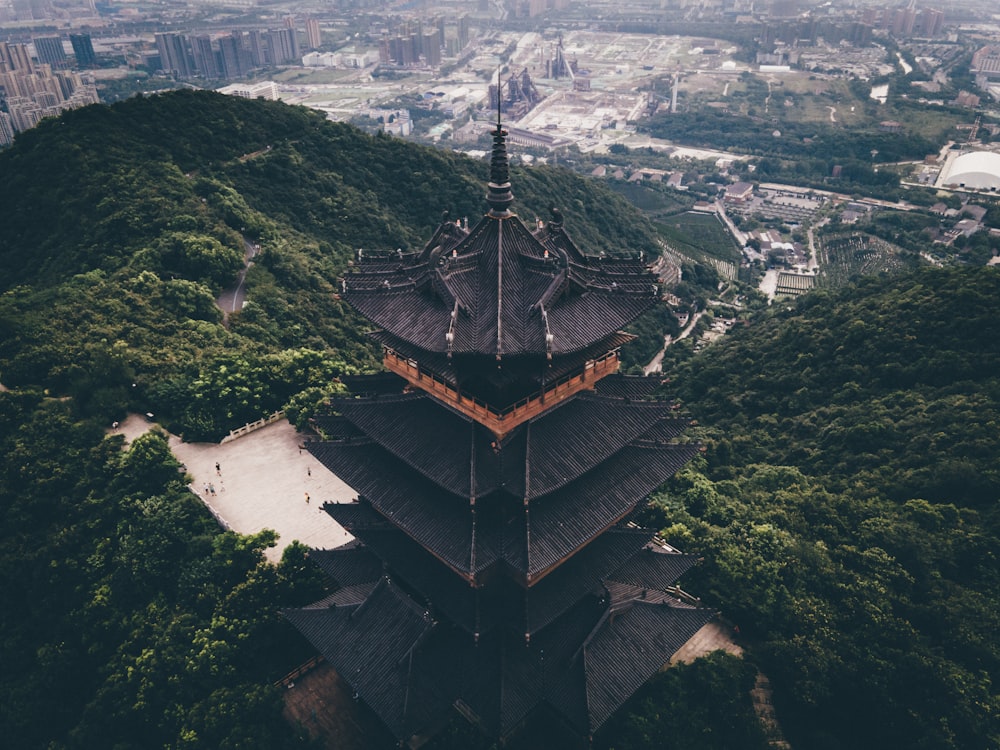 a tall building sitting on top of a lush green hillside