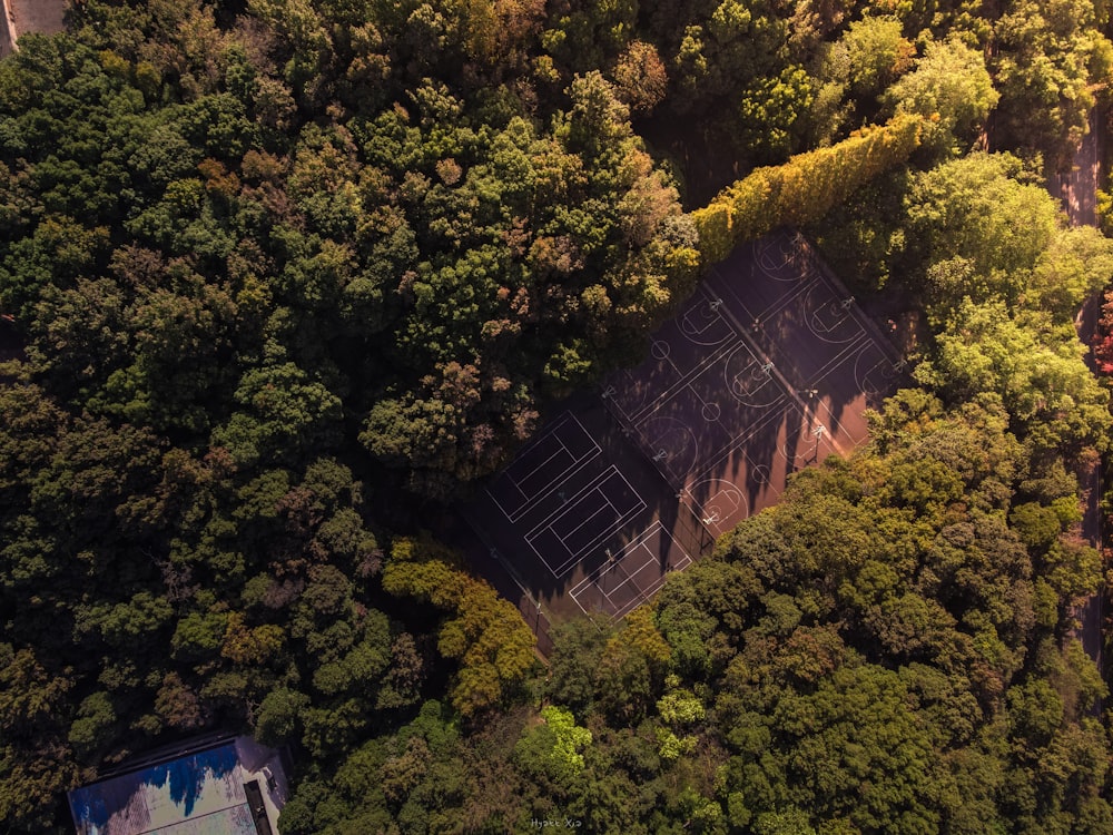 an aerial view of a tennis court surrounded by trees