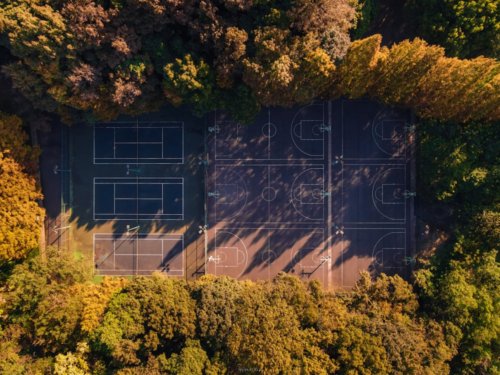 an aerial view of a tennis court surrounded by trees