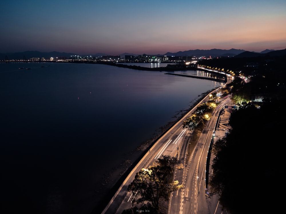 a night time view of a highway and a body of water