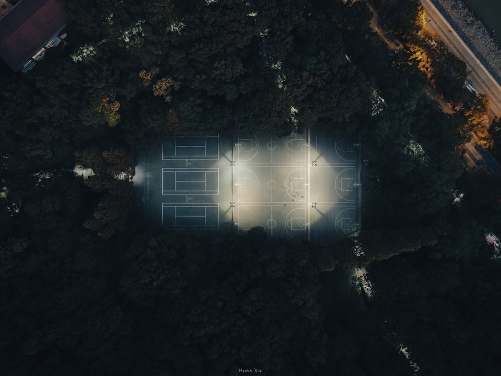 an aerial view of a tennis court surrounded by trees