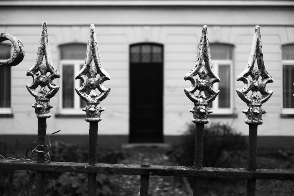 a black and white photo of a fence and a building