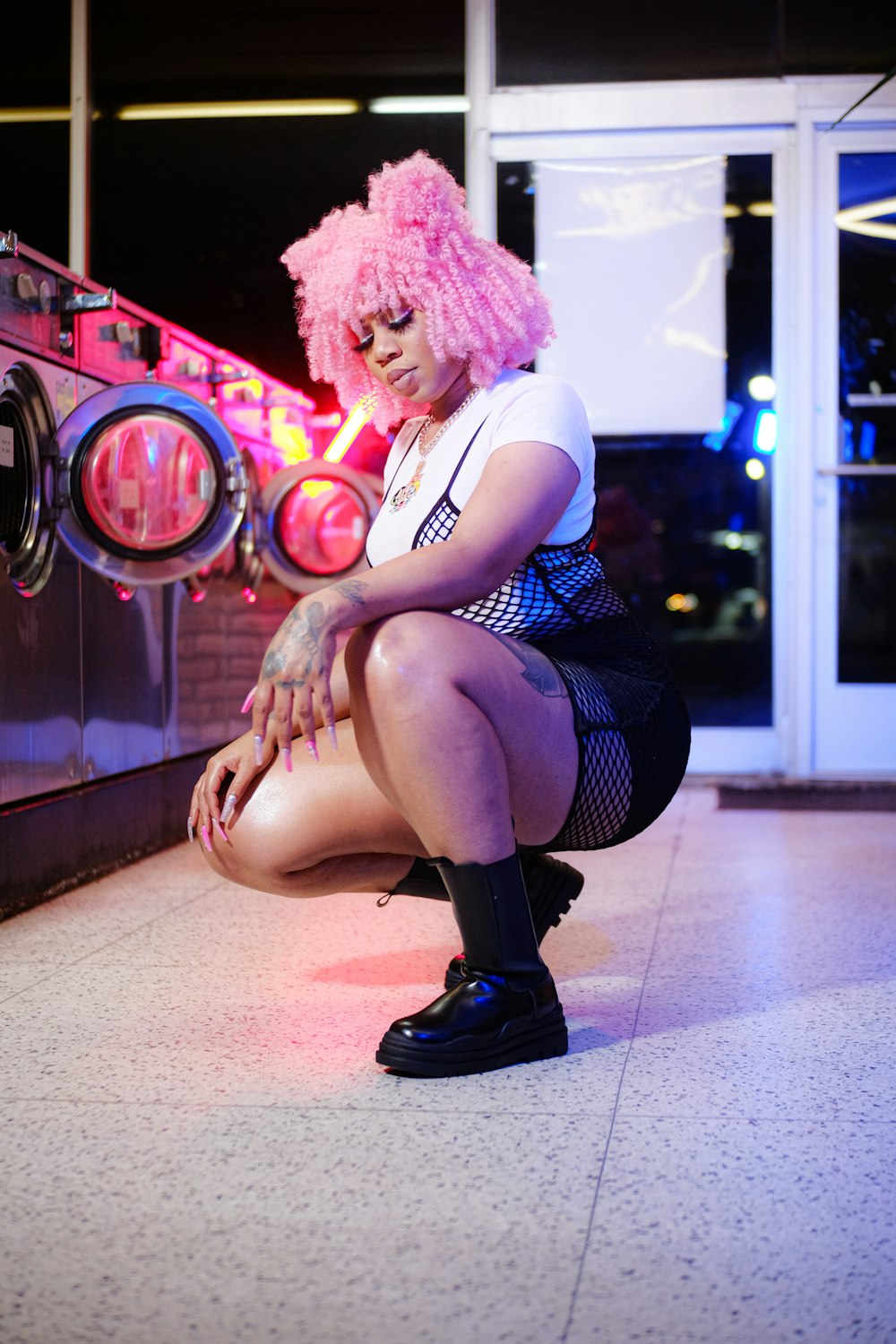 a woman with pink hair is sitting on the floor