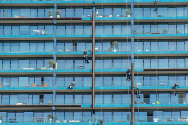 a group of people hanging off the side of a tall building