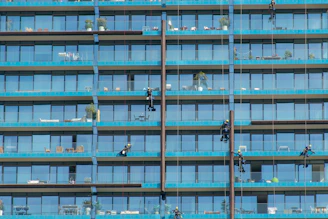 a group of people hanging off the side of a tall building