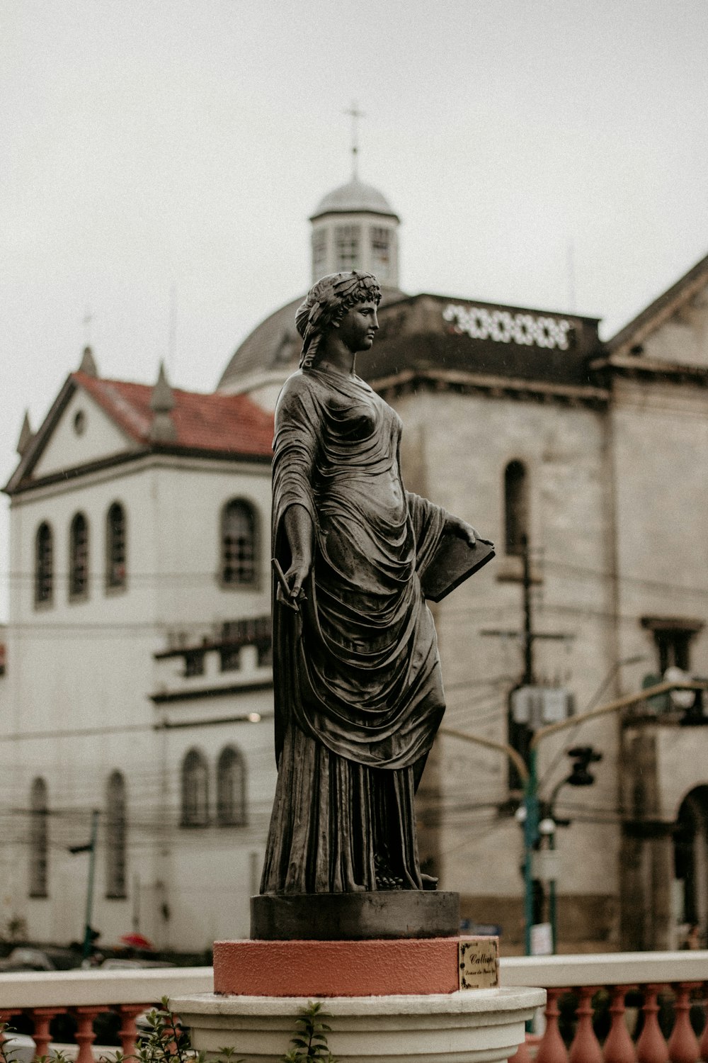 a statue of a woman standing in front of a building