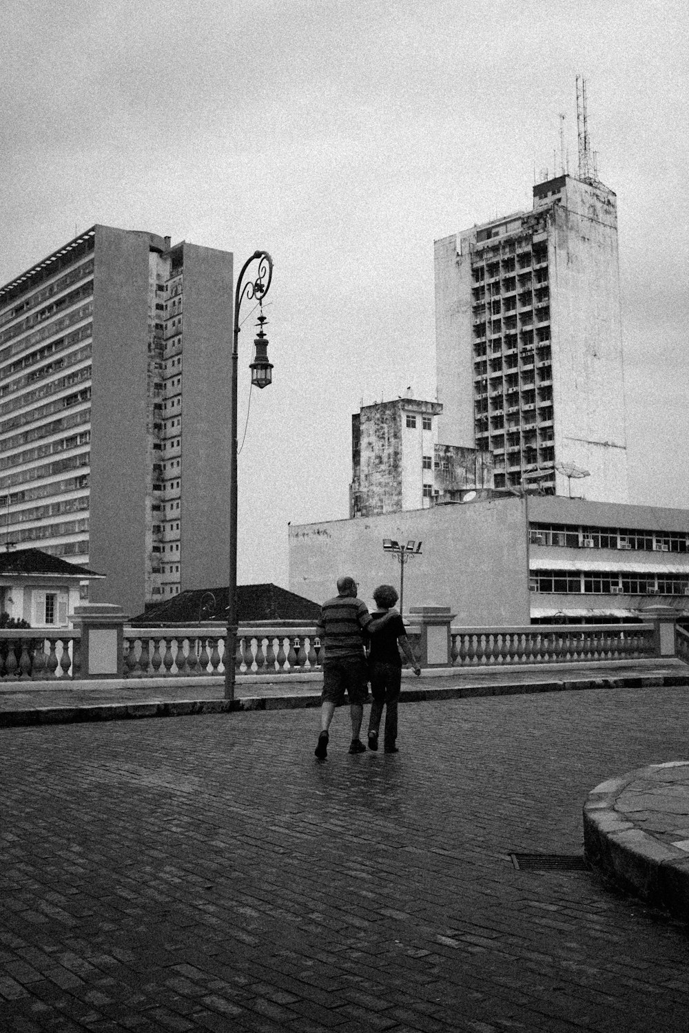 a couple of people standing on top of a brick road