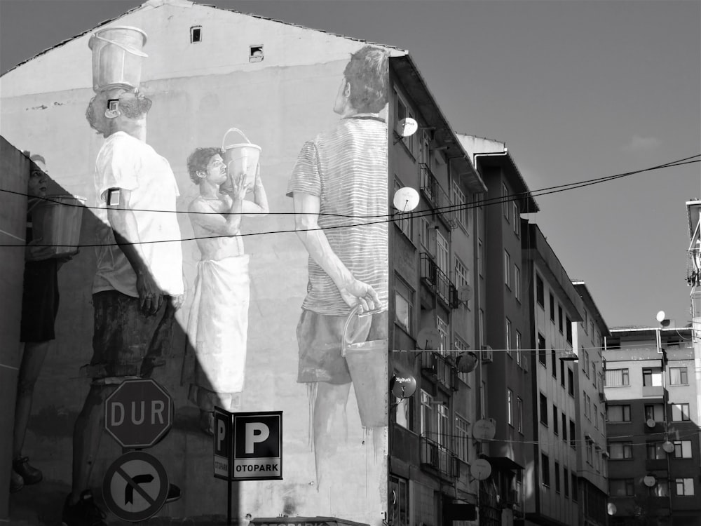 uma foto em preto e branco de um mural ao lado de um edifício