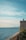 a person sitting on a ledge overlooking the ocean