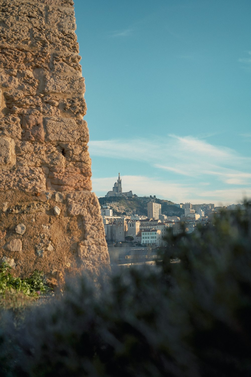 a stone wall with a clock tower in the background