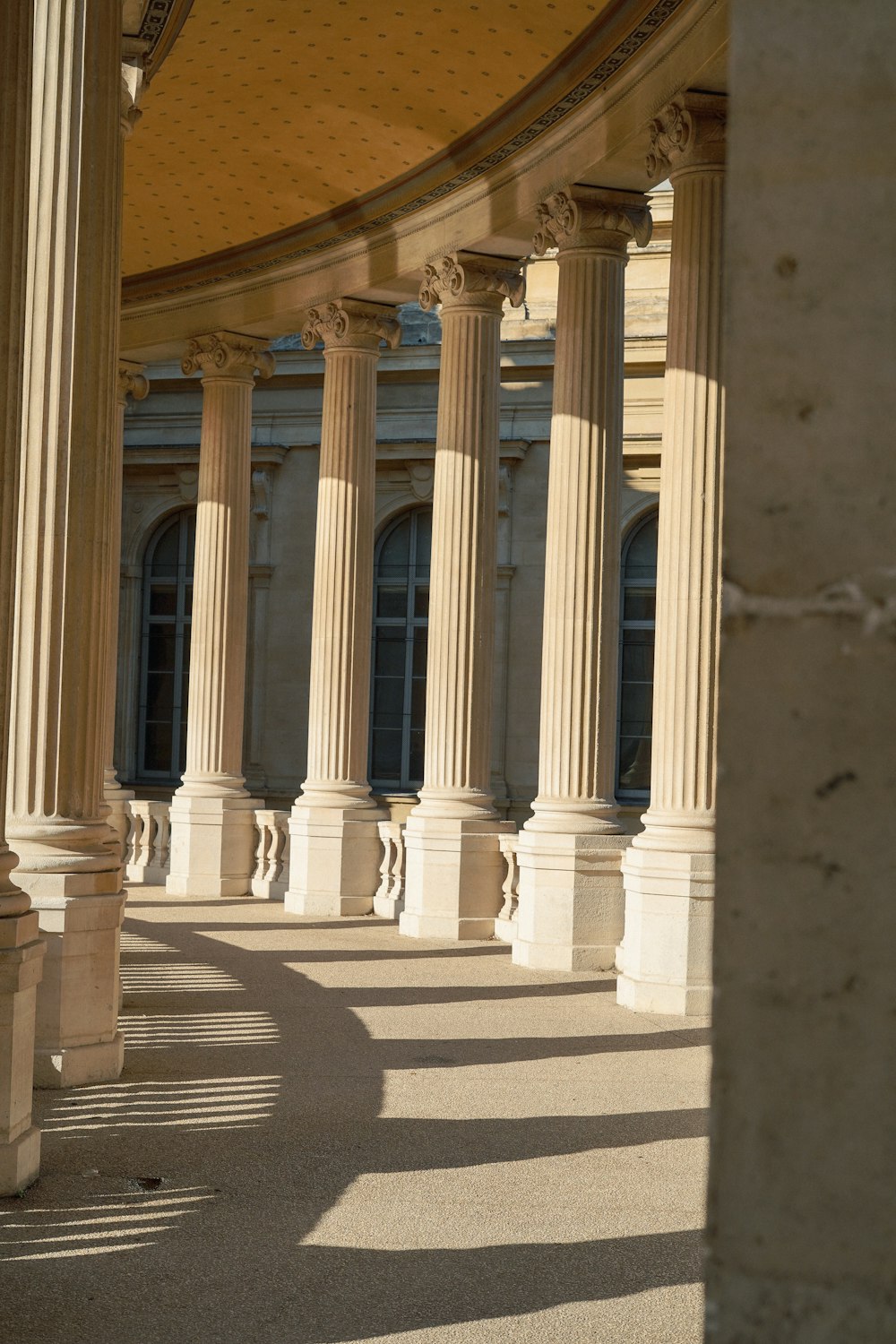 un grand bâtiment avec des colonnes et une horloge sur le mur