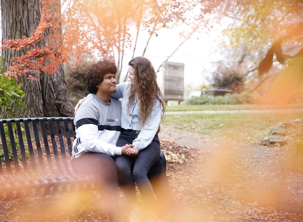 two women sitting on a bench in a park