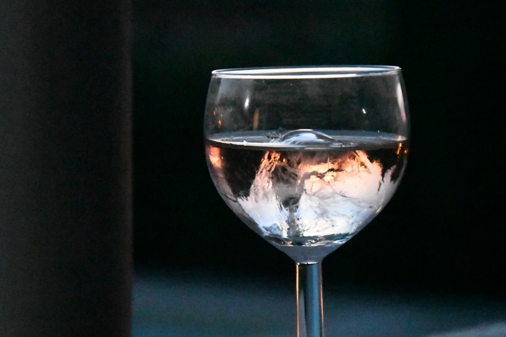 a glass of water with a mountain in the background