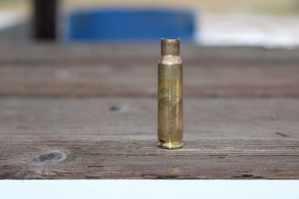 a close up of a bullet on a wooden surface