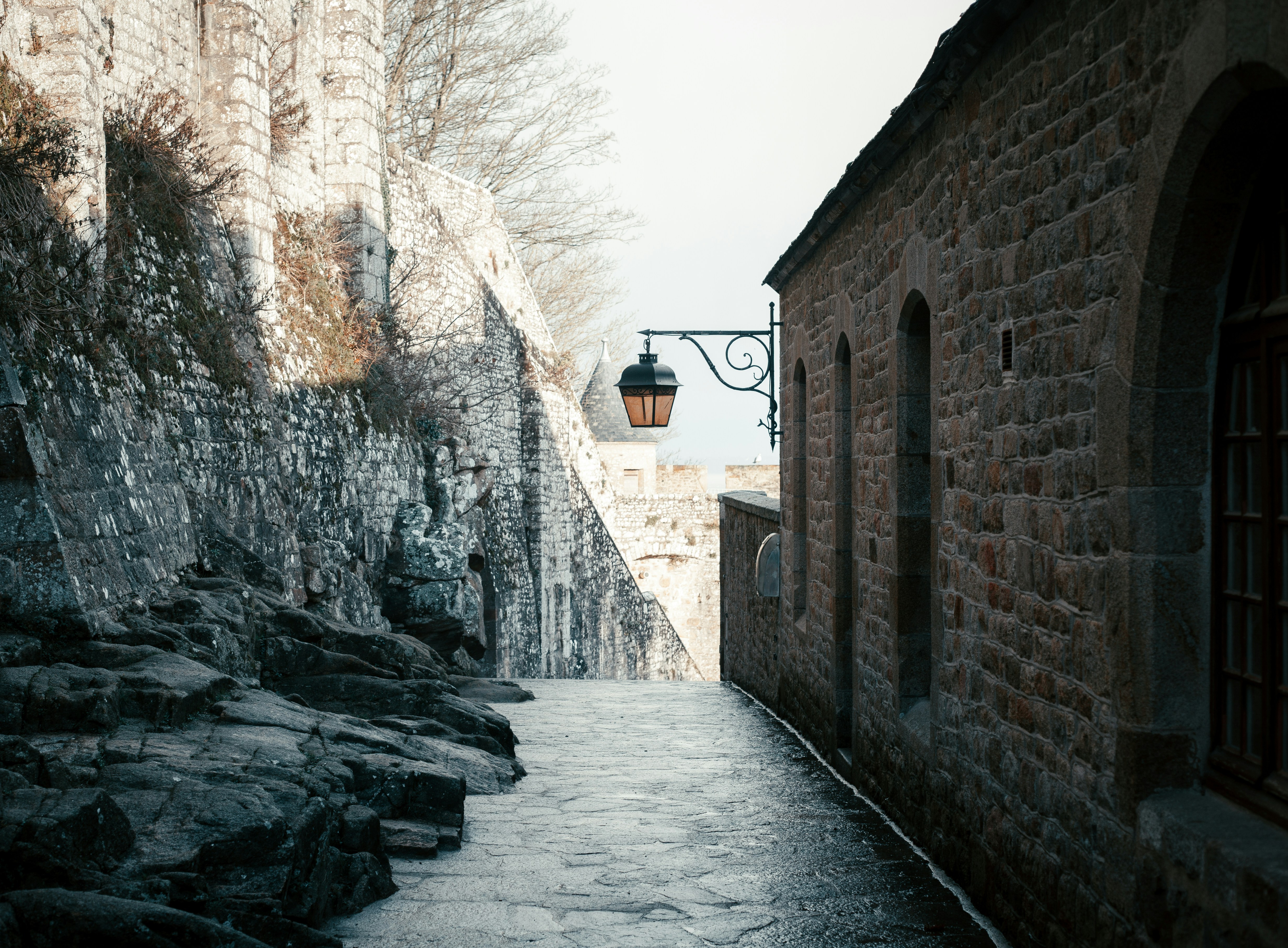 a cobblestone street leading to a stone building