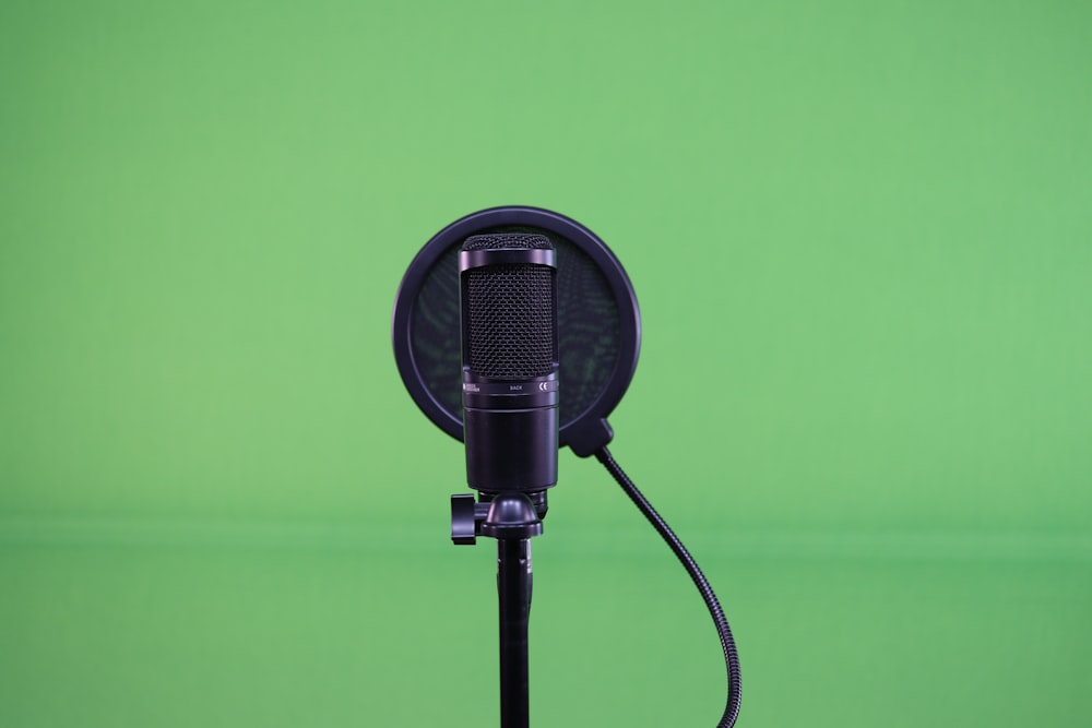 a microphone on a tripod with a green background