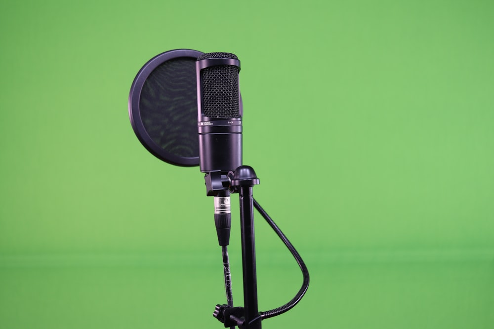 a microphone on a tripod in front of a green background