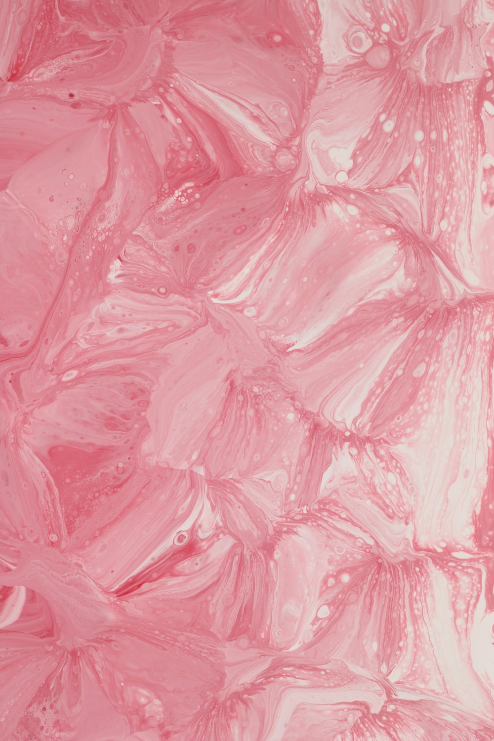 a close up of a pink background with water drops