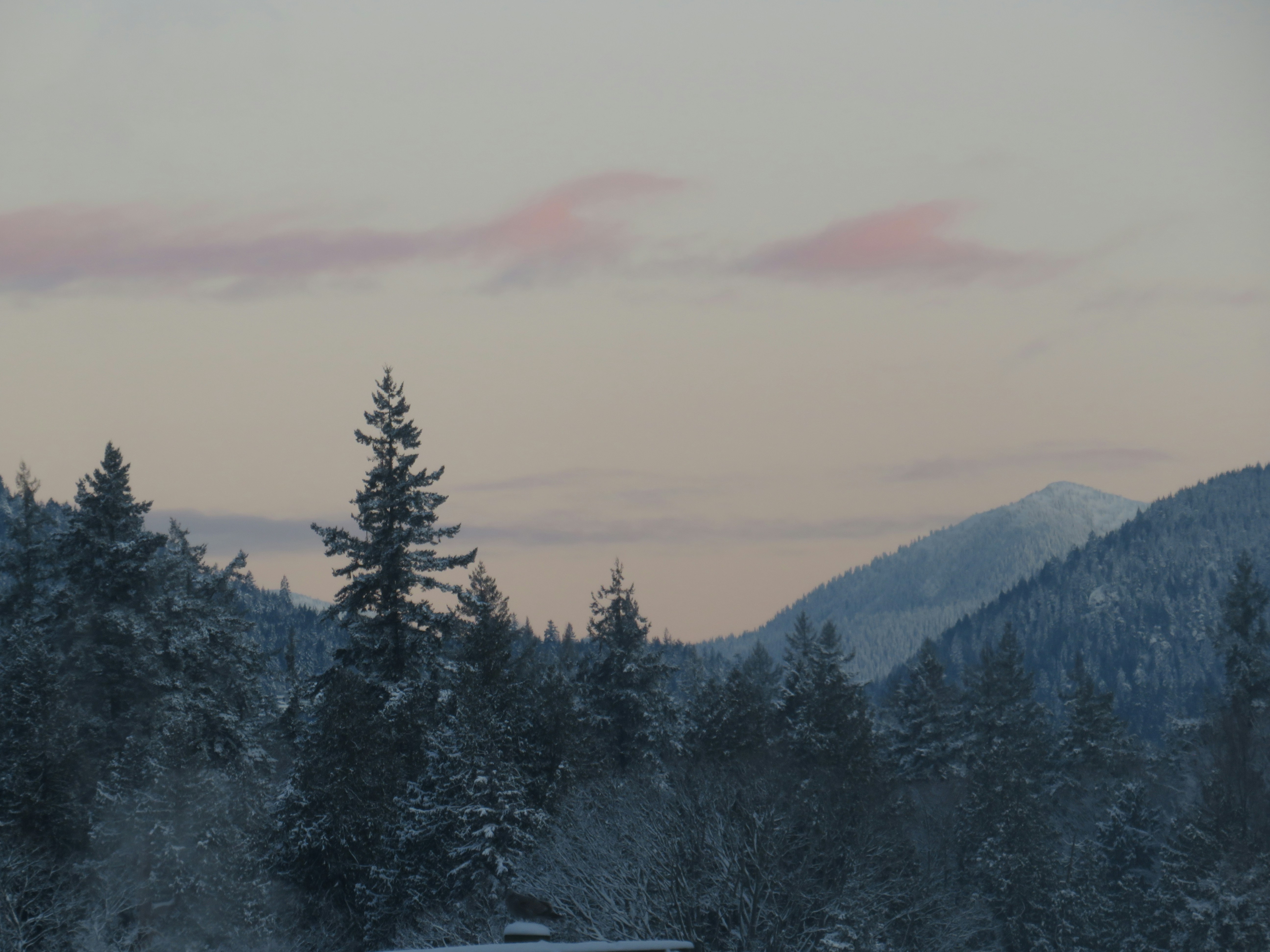 a truck driving down a snow covered road