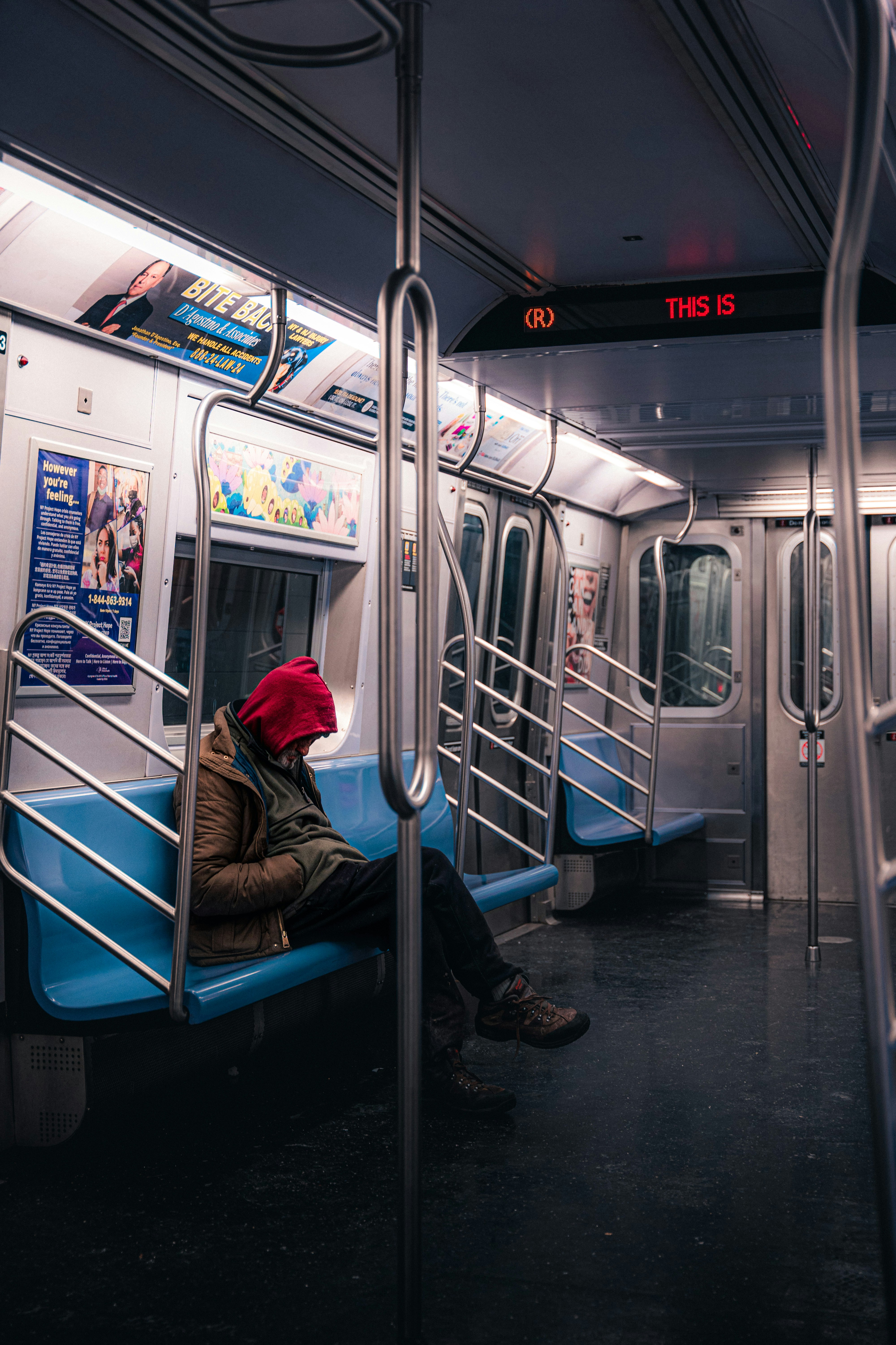 a person wearing a red hat sitting on a subway