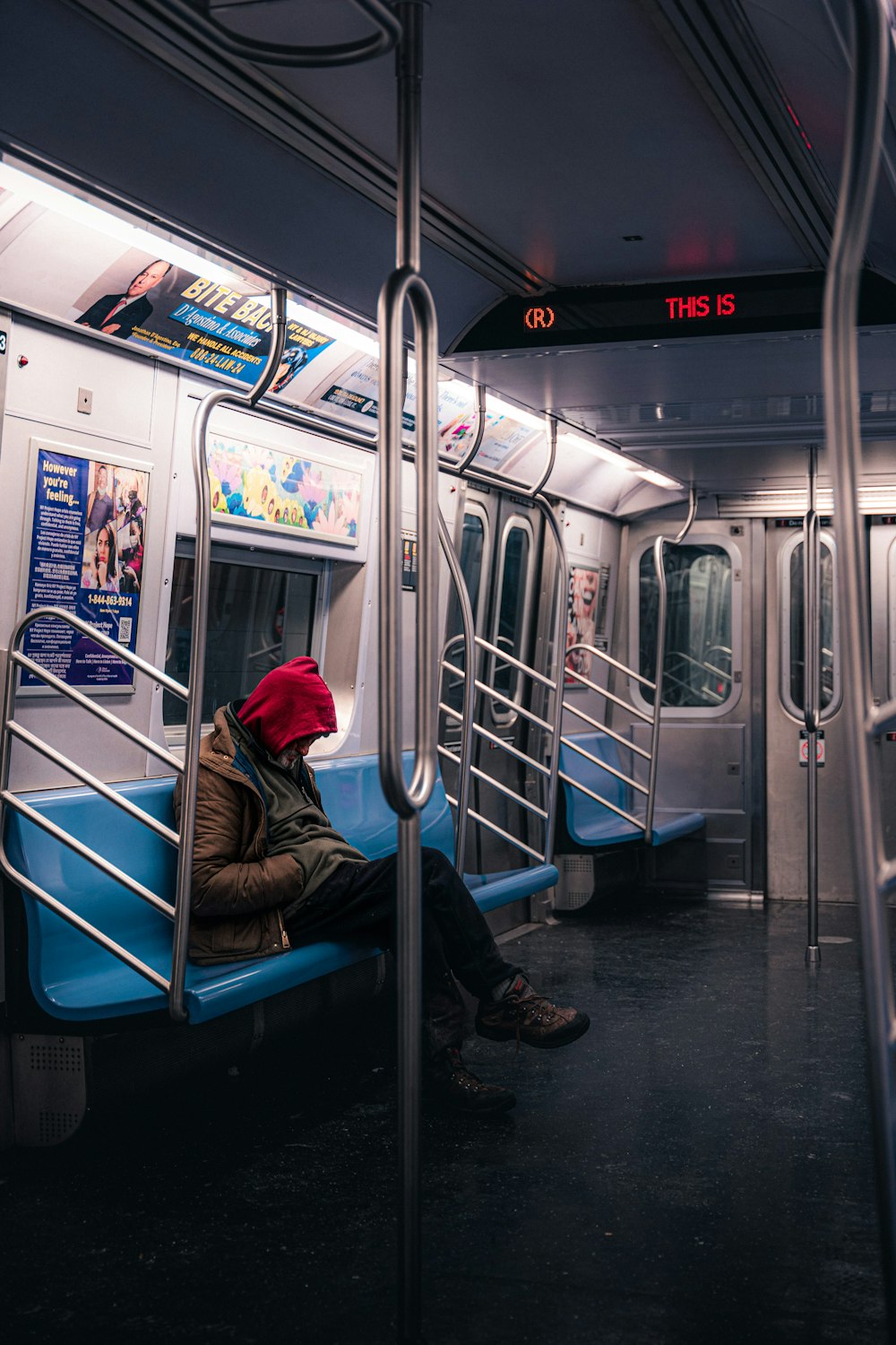 a person wearing a red hat sitting on a subway