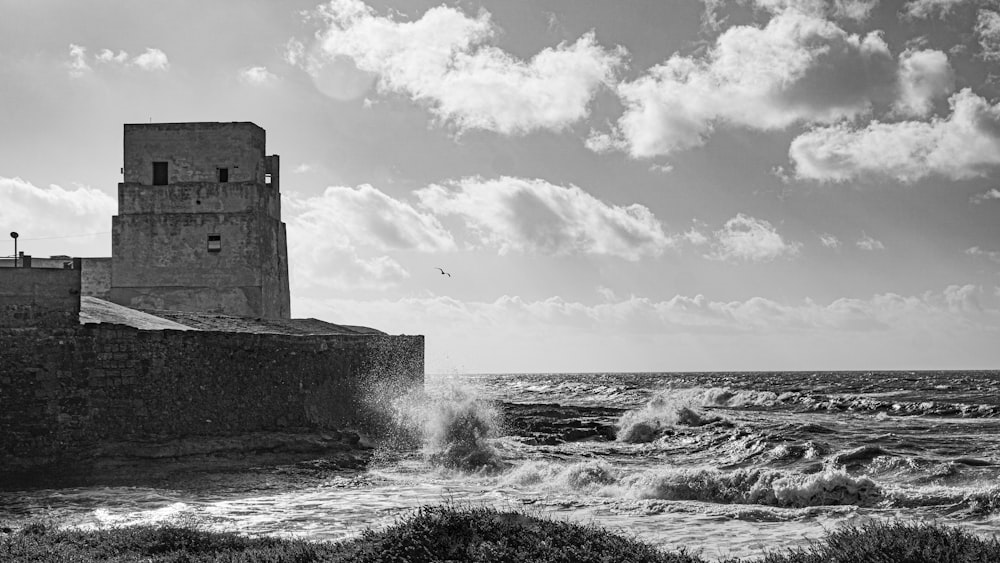 a black and white photo of waves crashing against a wall