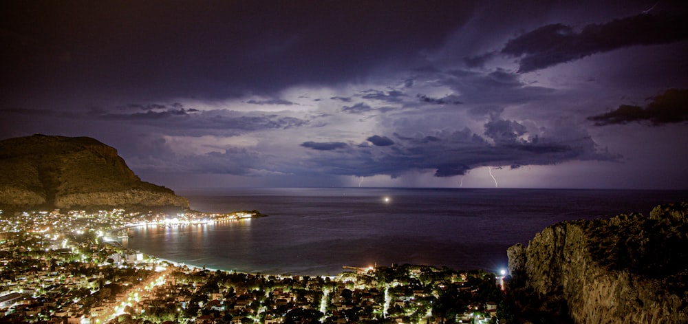 a storm is coming over a city by the ocean