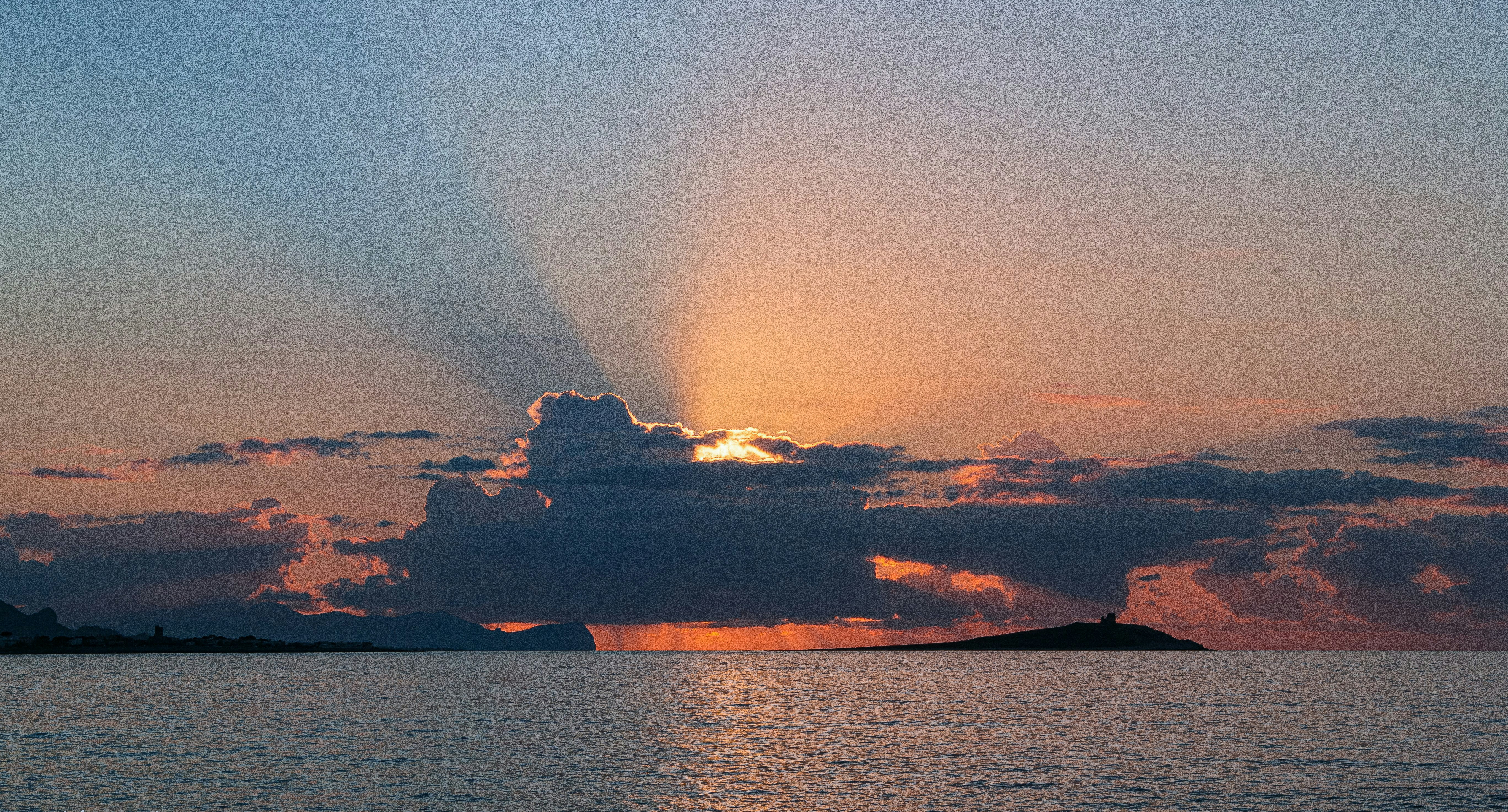 il sole che splende tra le nuvole su uno specchio d'acqua
