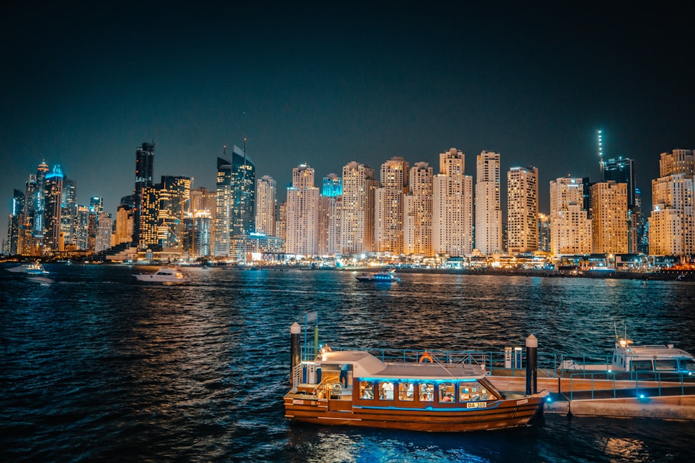 a boat floating on top of a body of water near a city