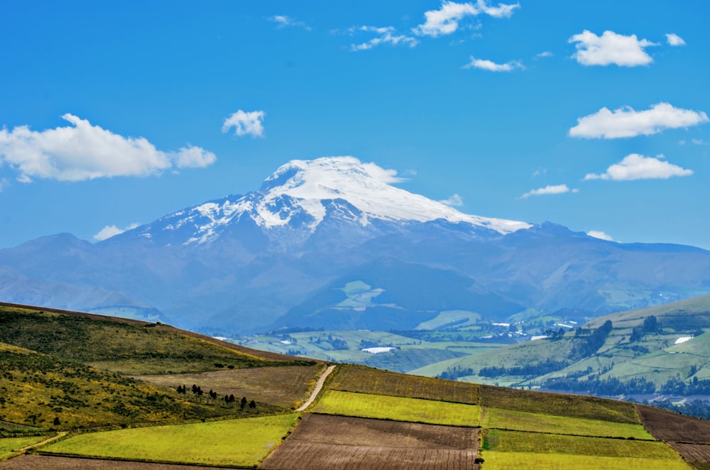 a mountain range with a snow capped peak in the distance