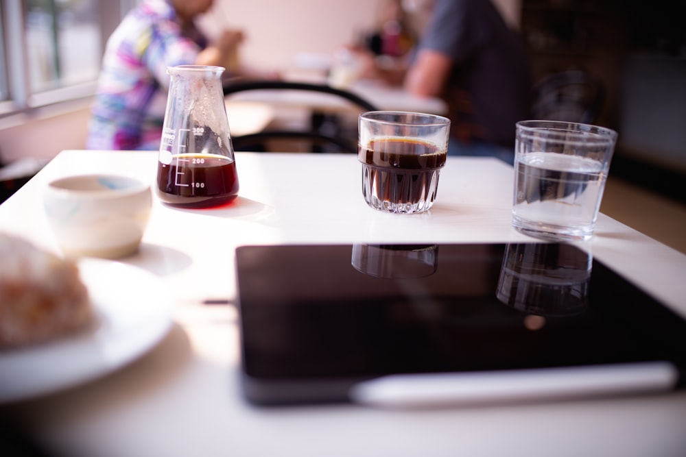 two glasses of liquid are sitting on a table