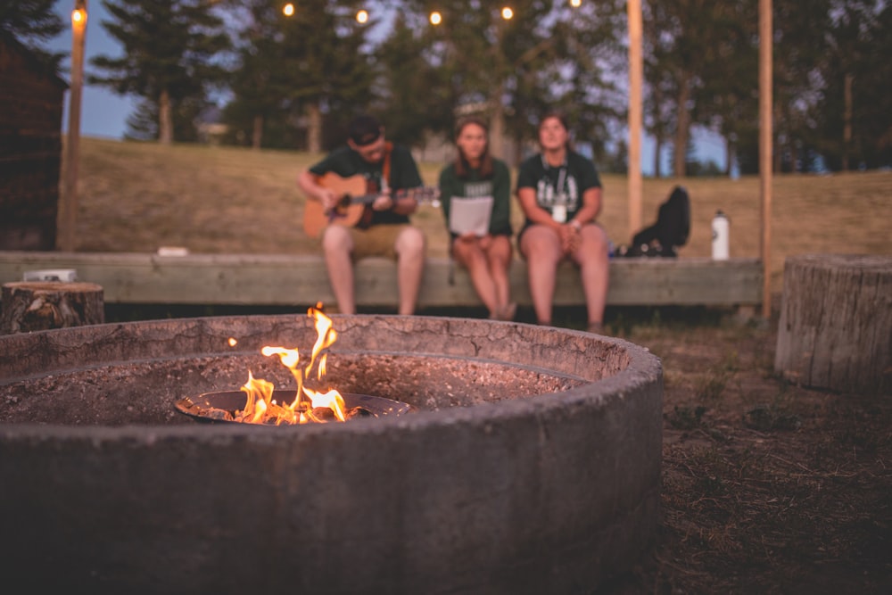 a group of people sitting around a fire pit