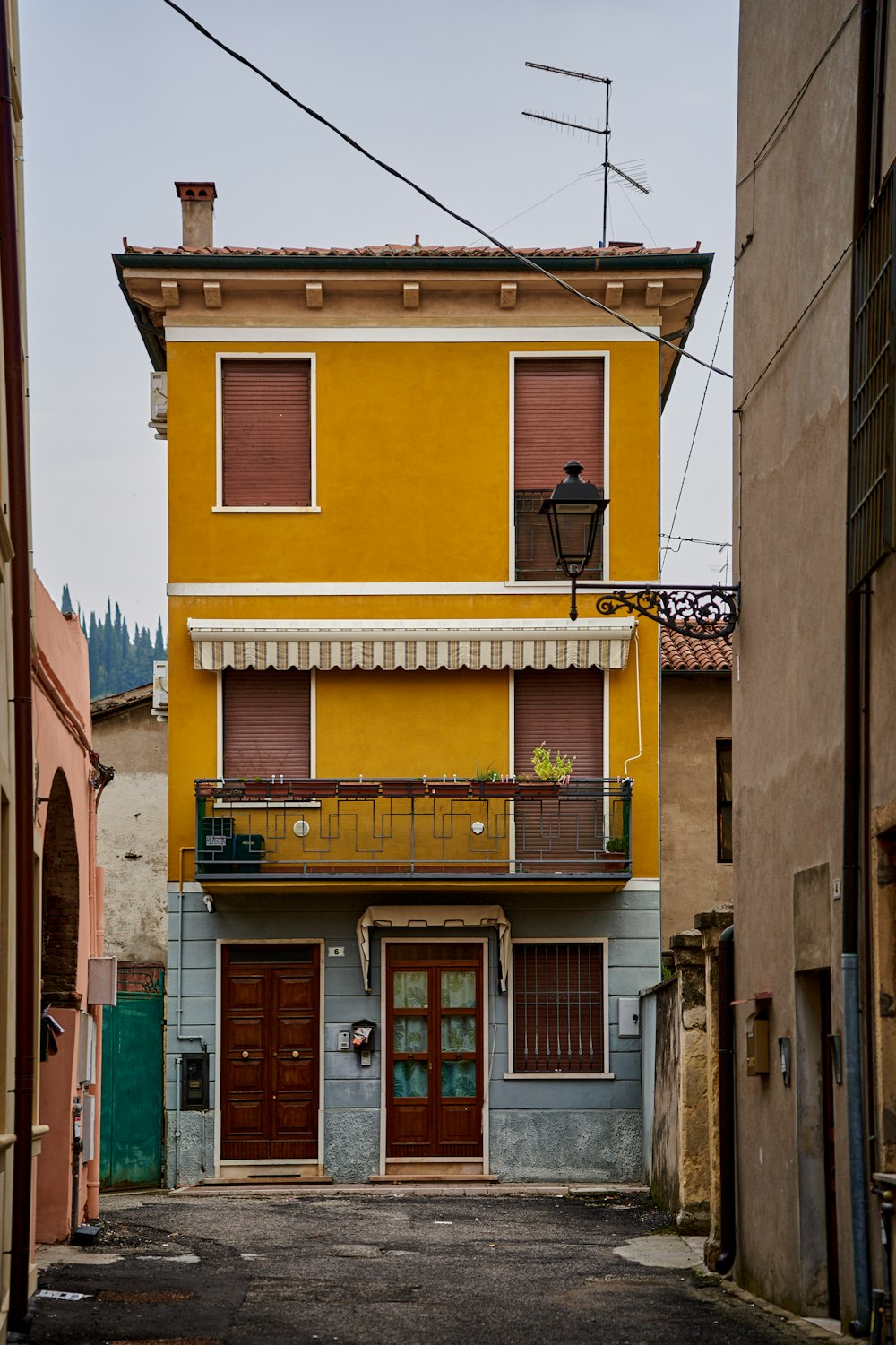 a yellow building with a red door and balcony