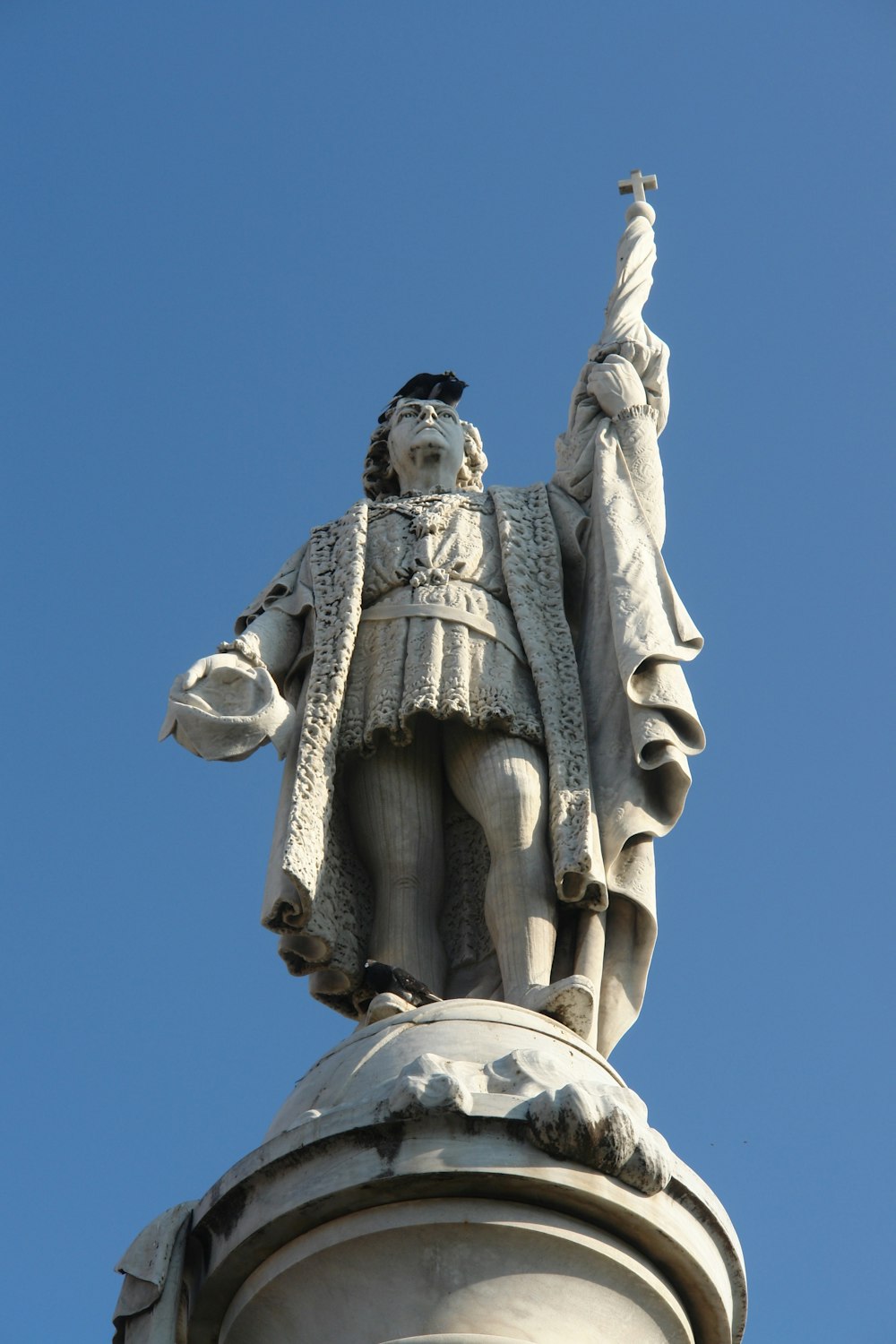 a statue of a man holding a bird on top of a building